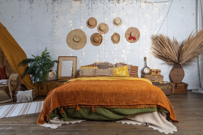 łóżko z pomarańczową narzutą w sypialni w stylu boho